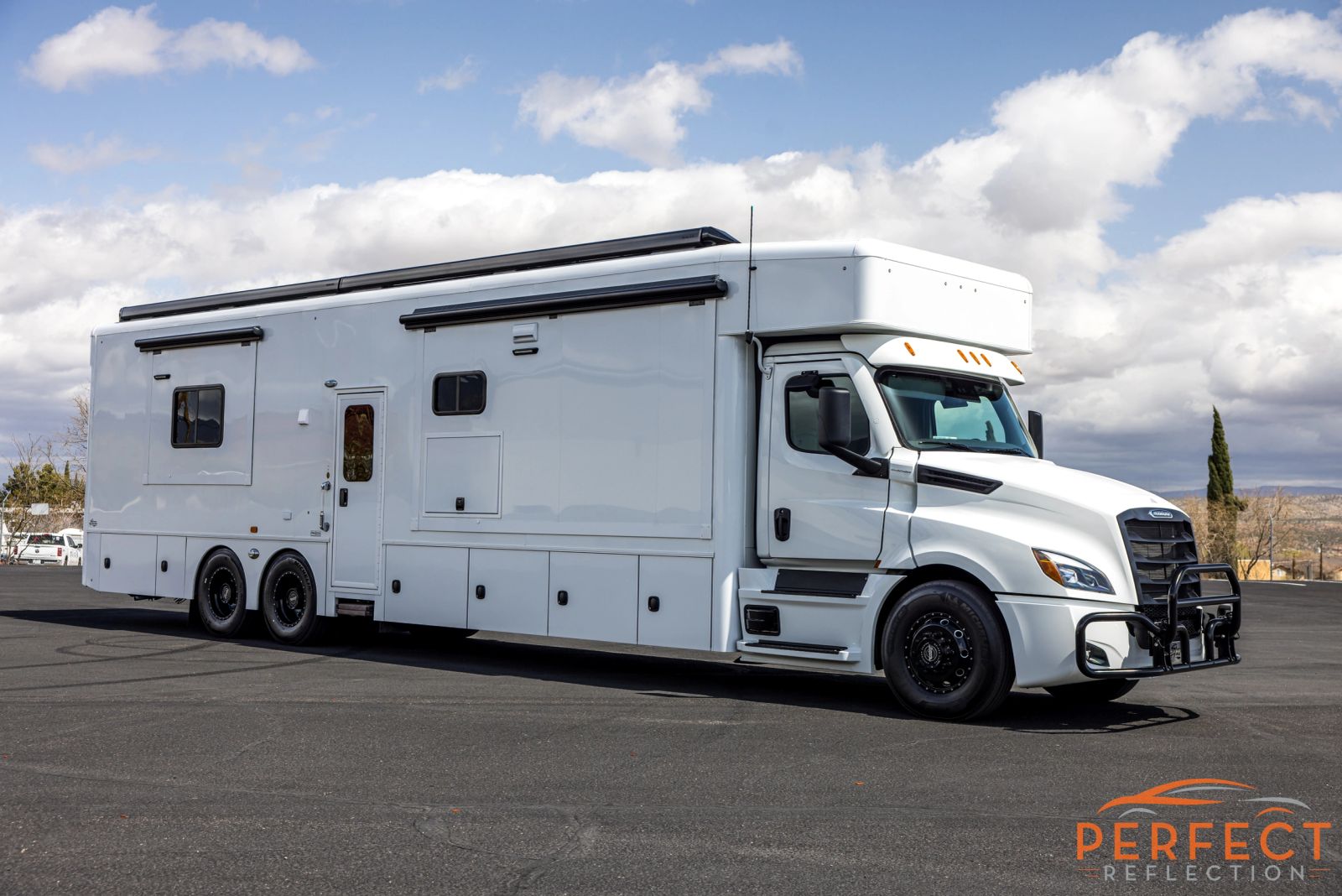 Large white RV hauler parked outdoors after detailing
